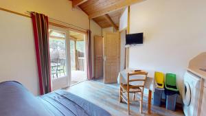 a room with a bed and a table and chairs at Domaine du Mas Bazan in Alénya