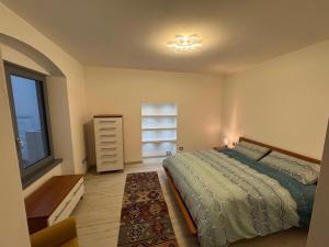 a bedroom with a bed and a dresser and a window at Casa Maddalena Lasino in Lasino