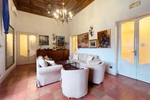 a living room with white furniture and a chandelier at Antica Dimora Caruso in Catania