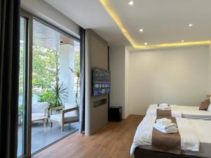 a bedroom with two beds and a balcony at Petit Hotel in Thu Dau Mot