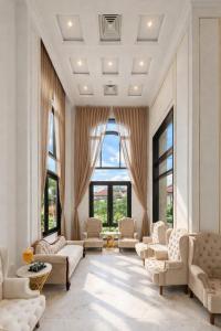 a living room with white furniture and large windows at Mira Boutique Hotel Quy Nhon in Quy Nhon