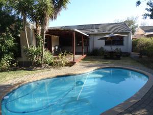 a swimming pool in front of a house at African Oasis Kenya in Somerset West