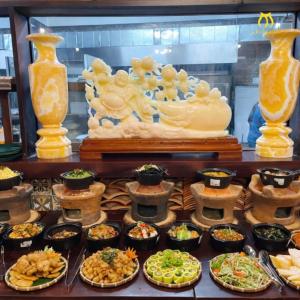 a buffet with many different types of food and vases at Mira Boutique Hotel Quy Nhon in Quy Nhon