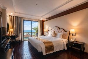 a bedroom with a large bed and a large window at Mira Boutique Hotel Quy Nhon in Quy Nhon