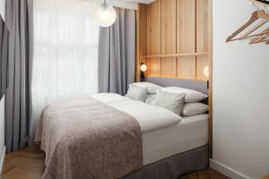 a bedroom with a bed with white sheets and pillows at Six Residences Prague in Prague