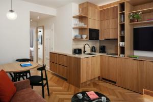 a kitchen with wooden cabinets and a living room at Six Residences Prague in Prague