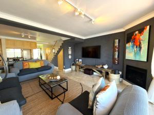 a living room with blue couches and a fireplace at Spinnaker Quays Waterfront Villa in Knysna