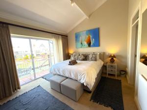 a bedroom with a bed and a large window at Spinnaker Quays Waterfront Villa in Knysna