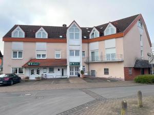 a large building with a car parked in front of it at Hotel Esmer in Lollar