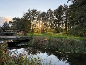 a bridge over a body of water with the sun setting at Entre sabots et ronrons in Butten