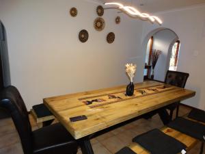 a dining room table with a vase of flowers on it at African Oasis Kenya in Somerset West