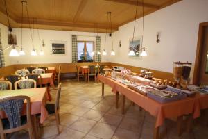 a dining room with tables and chairs in a restaurant at Hotel-Cafe Hanfstingl in Egling