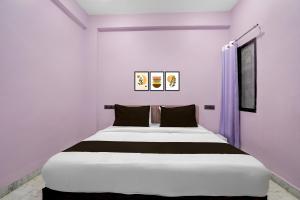 a white bedroom with a large bed in it at Hotel O G9 in Indore +20 photos