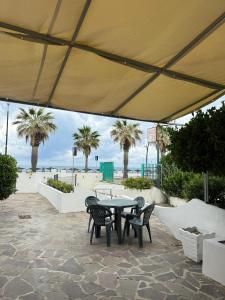 a patio with a table and chairs and palm trees at B&B Il Colore del mare in Agropoli +36 photos