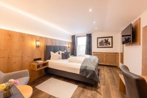 a hotel room with a bed and a tv at Hotel Alphof Stubaital in Fulpmes