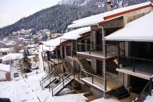 a building covered in snow with snow covered stairs at Chalet Christantoni in Elati Trikalon