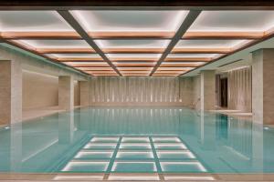 an indoor swimming pool with a ceiling of blue water at Le Meridien Batumi in Batumi