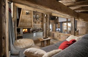 a living room with a couch and a fireplace at La Bouitte - Hôtel Relais & Châteaux in Saint-Martin-de-Belleville
