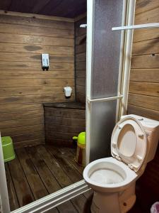 a bathroom with a toilet and a wooden floor at Mo Huai Su-桃園市民宿085號 in Hualing