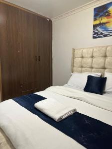 a bedroom with a large bed with a blue blanket on it at Infinite Stays in Thika