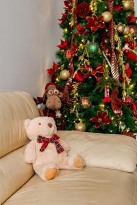 a teddy bear sitting on a couch in front of a christmas tree at Hotel Boutique Tunari in Tunari +150 photos