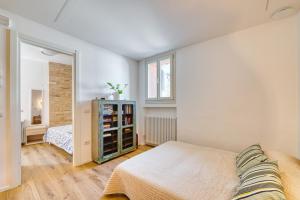 a white bedroom with a bed and a mirror at Torretta In Centro Perugia in Perugia