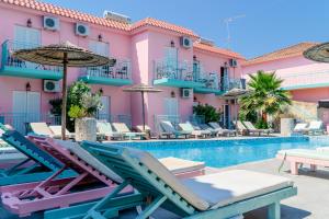 a resort with a swimming pool and lounge chairs at Maui Poolside Studios in Laganas