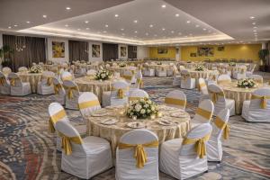 a banquet hall with round tables and yellow bows at Capitol Hill in Rānchī