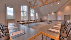 a room with tables and chairs in a classroom at Golfhotel Fahrenbach in Tröstau