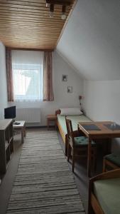 a bedroom with a bed and a desk and a table at PensionSchilling in Grasbrunn