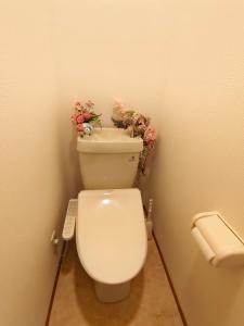 a bathroom with a toilet with flowers on top of it at DiDi Calm 105 in Tokushima +12 photos