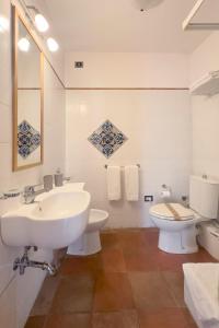 a white bathroom with a sink and a toilet at Antica Dimora Caruso in Catania