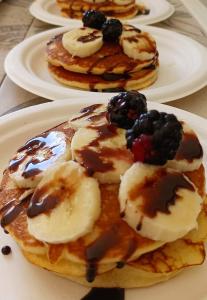 three plates of pancakes with syrup and fruit on them at Hotel Villa Cesare B&B in Alba Adriatica
