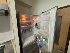 an open refrigerator with bottles of water and soda at hamanocho Ap in Shimminatomachi +31 photos
