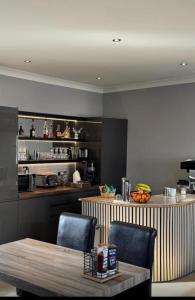 eine Küche mit Tisch, Stühlen und einer Theke in der Unterkunft Belstane Manor in Carluke