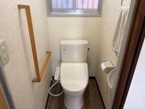a small bathroom with a white toilet and a window at hamanocho Ap in Shimminatomachi
