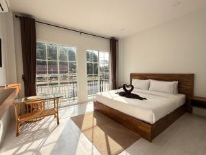 a bedroom with a bed and a large window at Chailai room202 in Ban Sai Thai