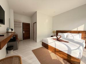 a bedroom with a large bed with a bow on it at Chailai room202 in Ban Sai Thai