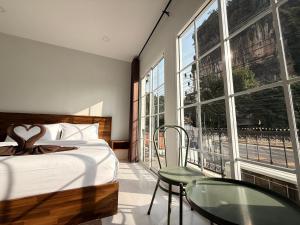 a bedroom with a bed and a large window at Chailai room202 in Ban Sai Thai +17 photos