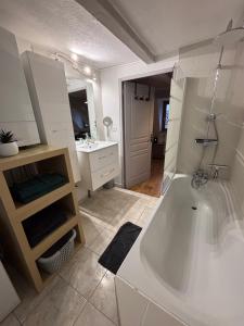 a white bathroom with a tub and a sink at Le Nid Alsacien - Centre Ville - Proche Parking Gratuit - Europa-park in Erstein