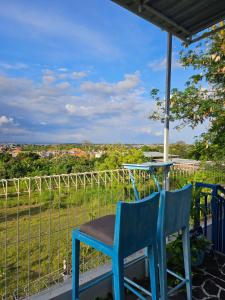 a blue chair sitting on a porch with a table at Nuansa Timur Residence in Jimbaran