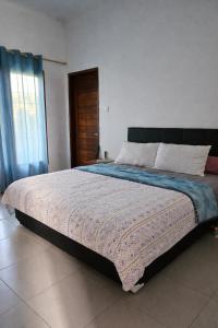 a bedroom with a large bed in a room at Nuansa Timur Residence in Jimbaran