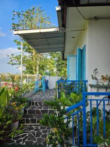 a patio with blue tables and chairs on a house at Nuansa Timur Residence in Jimbaran