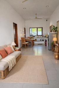 a living room with a couch and a kitchen at Nuansa Timur Residence in Jimbaran