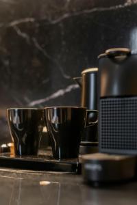 two cups sitting on a tray next to a coffee maker at Blanq Gran vía in Valencia +88 photos