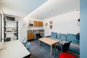 a living room with a couch and a table and chairs at Nut Hostel in Granada