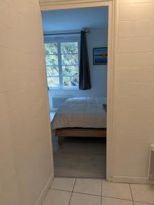 a bedroom with a bed and a window at Logement charmant à la montagne in Eaux-Bonnes
