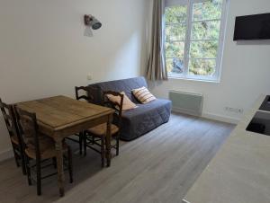 a living room with a blue couch and a table at Logement charmant à la montagne in Eaux-Bonnes