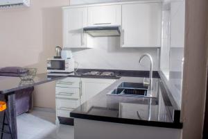 a kitchen with white cabinets and a sink at Samanyanga Resort in Kariba
