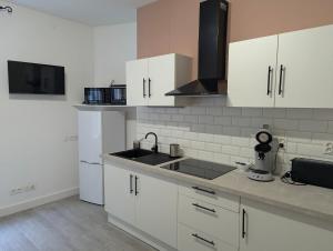 a kitchen with white cabinets and a sink at Logement charmant à la montagne in Eaux-Bonnes